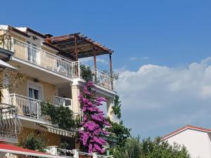 ein Gebäude mit lila Blumen auf der Seite in der Unterkunft Guest house Adria in Dugi Rat