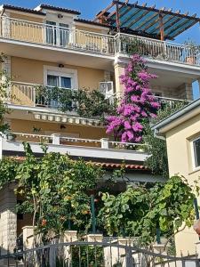 a building with pink flowers on the side of it at Guest house Adria in Dugi Rat