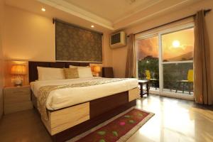 a bedroom with a large bed and a large window at Hotel 360 by D'Polo Dharamshala in Dharmsala