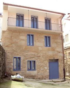 Casa de piedra grande con puertas y ventanas azules en Campo da Lúa 4, en Muros