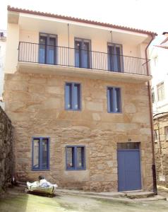 a large stone house with blue doors and windows at Campo da Lúa 4 in Muros