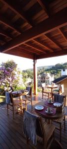 a wooden patio with tables and chairs on a deck at Chalés Lanelli in Monte Verde