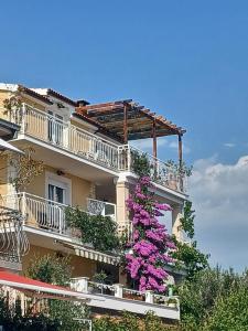 ein Gebäude mit rosa Blumen auf den Balkonen in der Unterkunft Guest house Adria in Dugi Rat