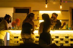 grupa ludzi stojących wokół baru w obiekcie Jungle by sturmfrei Palolem w mieście Palolem