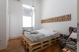 ein Schlafzimmer mit einem Bett auf einer hölzernen Plattform in der Unterkunft Second Home Apartment by Loft in Ljubljana