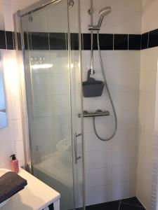 La salle de bains est pourvue d'une douche avec une porte en verre. dans l'établissement Numéro 5, à Boulogne-Billancourt