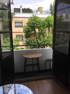 a table on a balcony with a view of a building at Numéro 5 in Boulogne-Billancourt