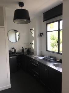 a black kitchen with a sink and a window at Numéro 5 in Boulogne-Billancourt