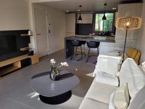 維琪奧港的住宿－Résidence Costa Nera Santa Giulia，客厅配有白色的沙发和桌子