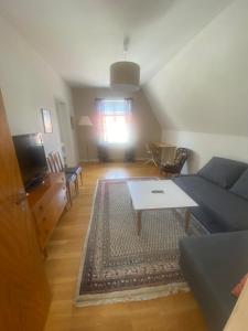 een woonkamer met een bank en een tafel bij Visby City Apartments S:t Hansgatan in Visby