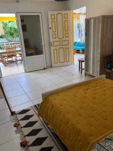 a bedroom with a bed and a sliding glass door at Ti Kaz À Patou, au coeur de l'île. in Baie-Mahault