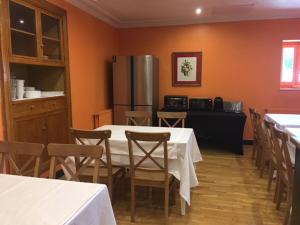 a dining room with tables and chairs and a refrigerator at Hostal Rural Oricáin in Oricáin