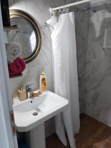 baño con lavabo y cortina de ducha en STATHIS GUESTHOUSE en Lefkada