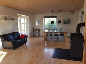 uma sala de estar com um sofá e uma mesa em Hus til stor familie em Bredebro