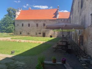 a table with an umbrella next to a building at Zámek Mokrosuky in Mokrosuky