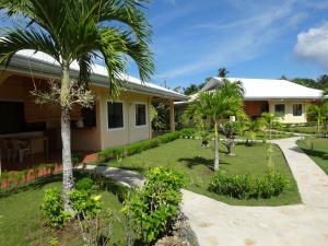 ein Haus mit einem Garten mit Palmen in der Unterkunft Bohol Sunside Resort in Panglao