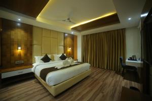 a hotel room with a large bed and a desk at Sree Fortune Grand, Tadepalli in Tādepalle