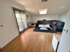 uma sala de estar com um sofá e uma mesa em Apartment Camellia em Ljubuski