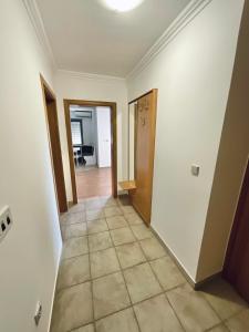 um corredor de uma casa com paredes brancas e piso de azulejo em Apartment Camellia em Ljubuski