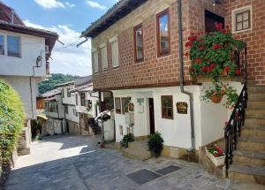 an alley in an old town with flowers on a building at Studio Paradise - Near Tsarevets&Central Location in Veliko Tŭrnovo