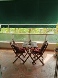 2 sillas y una mesa frente a un balcón en Apartamento Playa Victoria, en Cádiz