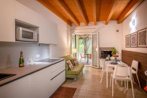 een keuken en een woonkamer met een tafel en stoelen bij Residence Duna Rossa in Duna Verde