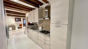 a kitchen with white cabinets and a stove at Ca' dell'Ombra Felice - canal view in Venice