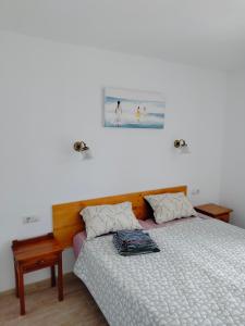 デニアにあるApartments Las Vinasのベッドルーム1室(ベッド1台付)が備わります。壁に絵が飾られています。