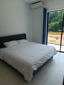 a bed in a room with a large window at RIVERSIDE PALM INN SG LEMBING in Sungai Lembing
