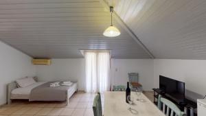 a living room with a bed and a television at Hotel Akropolis in Sivota