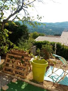 un jardín con cubo, mesa y silla en Hysope, en Château-Arnoux-Saint-Auban