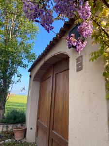 a garage with a wooden door with a field in the background at Monte Maino Bed & Breakfast in Desenzano del Garda