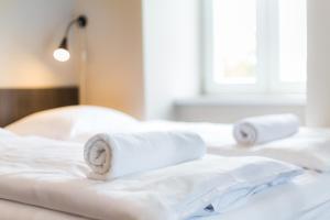 a white bed with two rolled towels on it at Minimino hotel in Prague