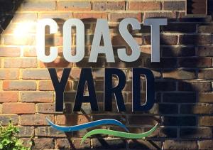 a sign on a brick wall with the words great yard at The Coast Yard B & B and Garden Chalets in Chichester