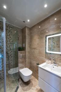 a bathroom with a toilet and a shower and a sink at Къща Катерков in Sozopol +42 photos