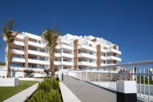 einen Außenblick auf ein weißes Apartmenthaus mit Palmen in der Unterkunft APARTMENT BY THE SEA CALACEITE in Torrox Costa