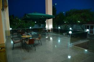 a patio with tables and chairs and an umbrella at Konstantin Hotel in Samarkand