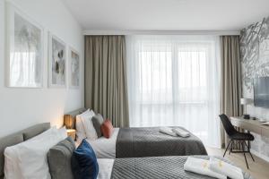 a hotel room with two beds and a couch at Emihouse Skyline Apartments in Rzeszów