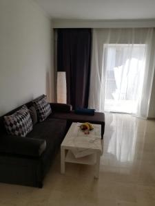 a living room with a couch and a coffee table at Apartment by the Sea, Peraia Thessaloniki in Perea