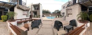 a courtyard with benches and a pool in a building at Laguna Park Duplex & Suites in Chascomús