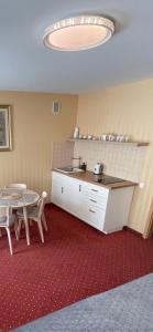 a kitchen with a table and a sink and a table at Morena Liux Apartment in Klaipėda
