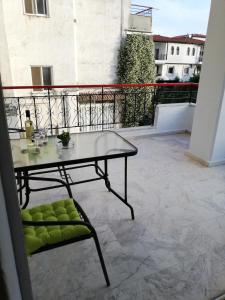 a table and a chair on a balcony at Apartment by the Sea, Peraia Thessaloniki in Perea