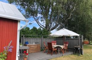 a patio with a table and chairs and an umbrella at Abbis lillstuga in Norra Vallgrund