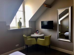 a room with a table and two chairs and a mirror at Hof van Alexander Boutiquehotel in Kerkwerve