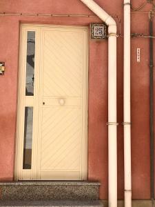 une porte blanche sur le côté du bâtiment dans l'établissement Sofi House, à Santo Stefano di Camastra