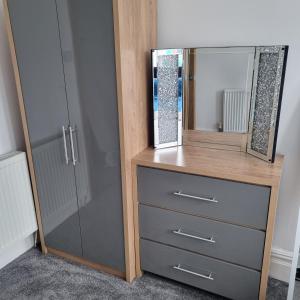 a dresser with a mirror on top of it at Blackpool Apartments in Blackpool