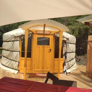 een yurt met een houten deur op een terras bij Glamping la Cascina d'Orleans in Saint-Pierre