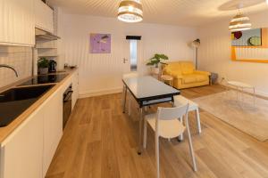 una cucina e un soggiorno con tavolo e sedie di Votre Maison Loin de Chez Vous a Châteaugay