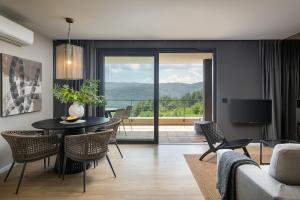 a living room with a table and chairs and a television at Oltremare Premium suite apartment w/pool in Rabac in Rabac +2 photos