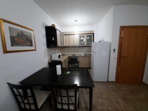 a kitchen with a black table and a white refrigerator at Doen apartment in Orikum